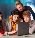 4 studenten kijken naar een laptop beeldscherm